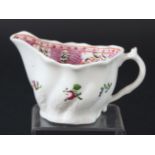 LOWESTOFT LOW CHELSEA EWER CREAM JUG, circa 1770, painted with a band of floral panels on a pink