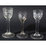 GROUP OF THREE WINE GLASSES, circa 1760, the ogee bowls with floral and bird engraved decoration