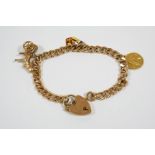 A 9CT. GOLD CURB LINK BRACELET with padlock clasp and suspending three 9ct. gold charms, total
