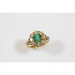 AN EMERALD AND DIAMOND CLUSTER RING the octagonal-shaped emerald is set within a surround of eight