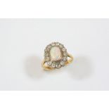 AN OPAL AND DIAMOND CLUSTER RING the oval-shaped solid white opal is set within a surround of old