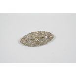 AN ART DECO DIAMOND BROOCH the openwork scrolling design is mounted with graduated cushion-shaped