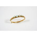 AN OPAL AND GOLD HALF HINGED BANGLE the 15ct. gold bangle set to one side with two oval-shaped and