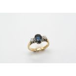 A SAPPHIRE AND DIAMOND THREE STONE RING the oval-shaped sapphire is set with two circular-cut