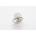 A DIAMOND CLUSTER RING the circular-cut diamond is set within a surround of baguette-cut and