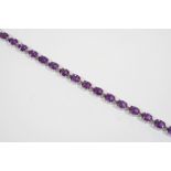 AN AMETHYST AND GOLD BRACELET the 18ct. gold bracelet is mounted with eighteen oval-shaped