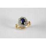 A SAPPHIRE AND DIAMOND CLUSTER RING the oval-shaped sapphire is set within a surround of ten