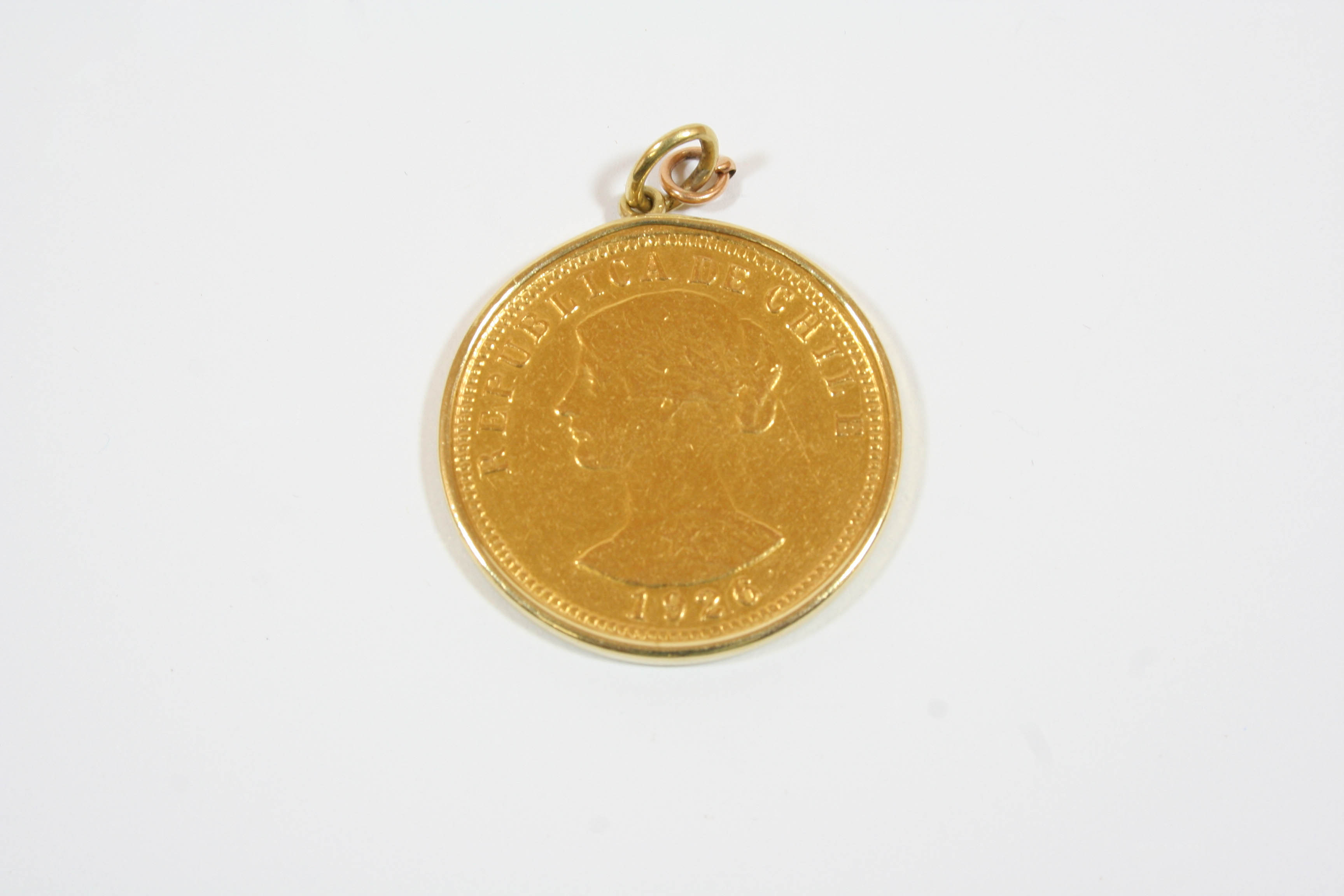 A CHILEAN 100 PESOS COIN 1926, in a gold pendant mount, total weight 22.1 grams.