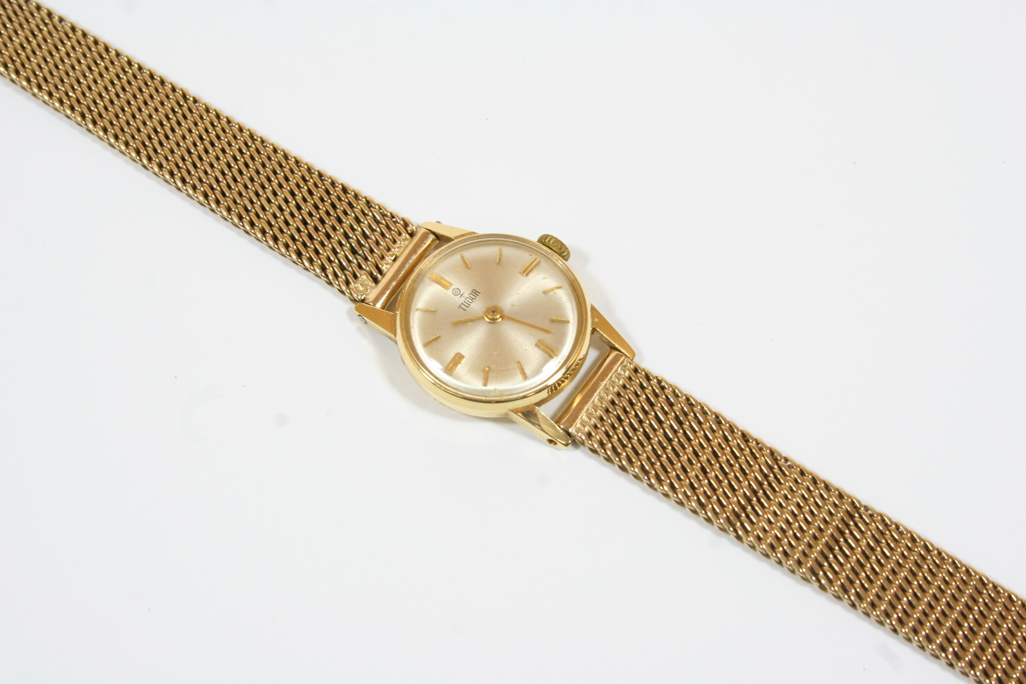 A LADY'S 9CT. GOLD WRISTWATCH BY TUDOR ROLEX the signed white enamel dial with baton numerals, on