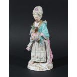 MEISSEN FIGURE OF A LADY, 19th century, standing holding a posy of flowers and a muff, blue