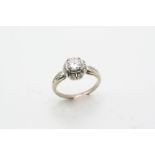 A DIAMOND CLUSTER RING the round brilliant-cut diamond weighs 0.76 carats and is set within a