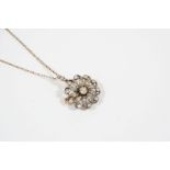 A VICTORIAN DIAMOND BROOCH PENDANT of flowerhead form and set overall with graduated old brillint-