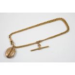 A 9CT. GOLD CURB LINK WATCH CHAIN with 9ct. gold 't' bar and suspending a gold plated locket,