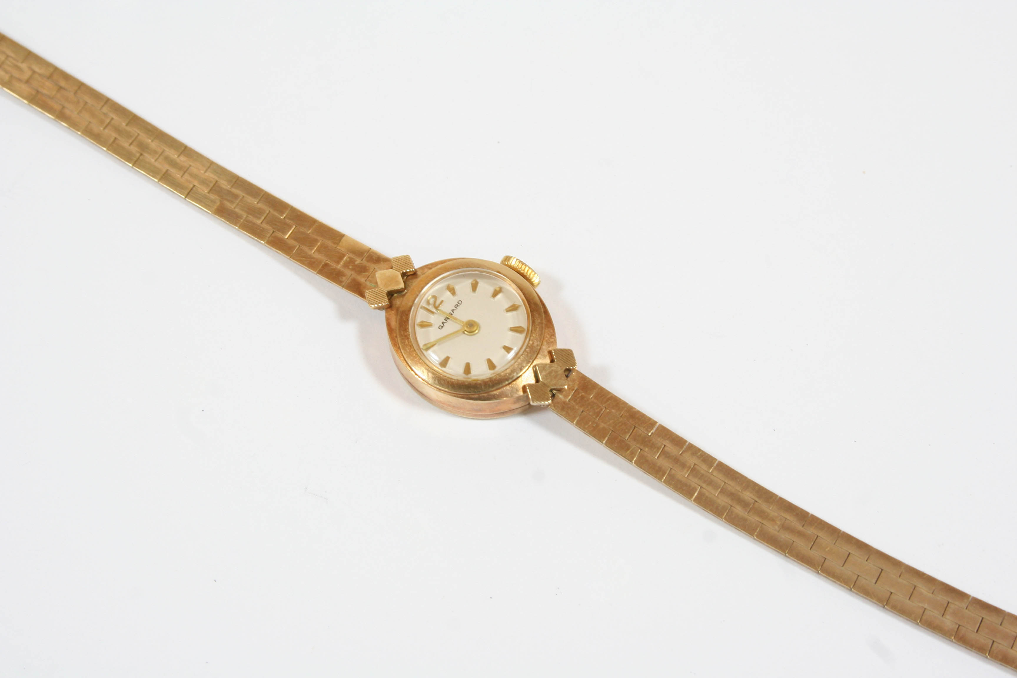 A LADY'S 9CT. GOLD WRISTWATCH BY GARRARD the signed circular dial with dagger numerals and one