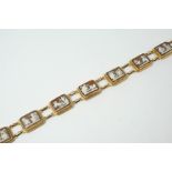 A CARVED SHELL CAMEO BRACELET formed with seven rectangular shell cameo plaques depiciting classical