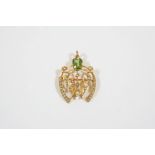 AN EDWARDIAN PERIDOT AND PEARL SET PENDANT the openwork foliate design is set with a rectangular-