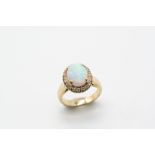 AN OPAL AND DIAMOND CLUSTER RING the oval-shaped solid white opal is set within a surround of