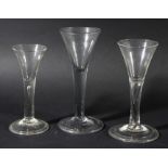 GROUP OF THREE WINE GLASSES, circa 1770, the drawn trumpet bowls above plain stems, two with