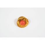 A GOLD AND CORAL SHELL BROOCH the gold shell with a coral 'pearl' in its centre, 3cm. wide. In