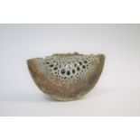 ALAN WALLWORK (BORN 1931) a thin stoneware wedge form vessel, with pierced holes on each side.