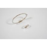 AN 18CT. WHITE GOLD AND DIAMOND BANGLE the half hinged bangle is mounted to one side with three