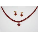 A RUBY AND GOLD NECKLACE mounted with forty five graduated square-shaped rubies in gold, on a gold