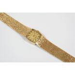 A LADY'S 9CT. GOLD WRISTWATCH the cushion-shaped dial signed Geneve and with baton numerals,