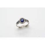 AN EARLY 20TH CENTURY SAPPHIRE AND DIAMOND CLUSTER RING the oval-shaped sapphire is set within a