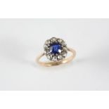 A DIAMOND AND SYNTHETIC SAPPHIRE CLUSTER RING the circular synthetic sapphire is set within a