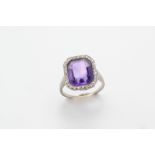 AN EARLY 20TH CENTURY AMETHYST AND DIAMOND CLUSTER RING the cut cornered rectangular-shaped amethyst