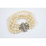 A DIAMOND AND CULTURED PEARL BRACELET formed with four rows of uniform cultured pearls measuring