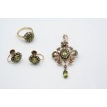 AN EDWARDIAN PERIDOT AND PEARL SET PENDANT the openwork foliate gold mount is set with an oval-