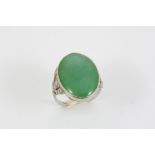 AN ART DECO JADE AND DIAMOND RING the oval section of jade is mounted with single-cut diamonds to