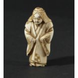 JAPANESE IVORY NETSUKE, Meiji, carved as a figure standing in a full length robe, signed, height