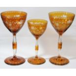 SET OF SIX BOHEMIAN STYLE GLASSES, amber cut through to clear, the rounded bowls engraved with