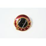 A VICTORIAN BANDED AGATE AND ENAMEL MOURNING BROOCH of gold buckle design, the section of banded