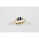 A SAPPHIRE AND DIAMOND THREE STONE RING the rectangular-shaped sapphire is set with two circular-cut