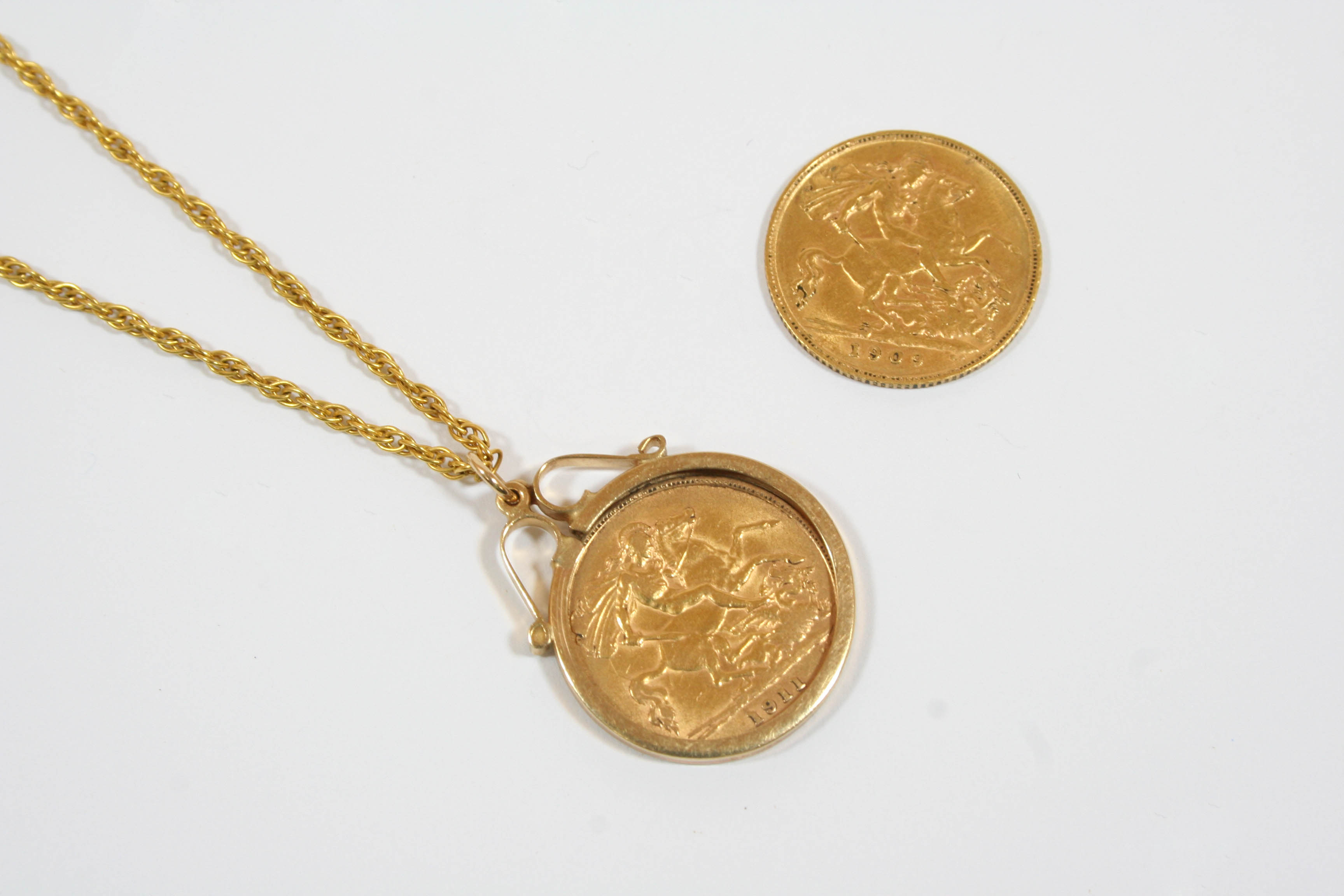 A GOLD HALF SOVEREIGN 1911, in a 9ct. gold mount and on a fine link chain, total weight 8.0 grams,