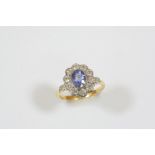 A SAPPHIRE AND DIAMOND CLUSTER RING the oval-shaped sapphire is set within a surround of ten