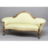 VICTORIAN WALNUT FRAMED SOFA, with a floral carved and scrolling frame and light green upholstery,