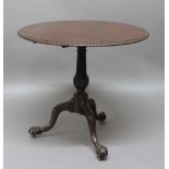GEORGE III CIRCULAR TRIPOD TABLE, the top with a stiff leave carved rim on a turned and carved