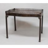 GEORGE III STYLE MAHOGANY SILVER OR CHINA TABLE, of serpentine form with fretwork gallery, canted