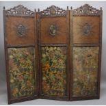 CARVED OAK THREE-FOLD SCREEN, each panel surmounted by a crest above cane-work with further crests