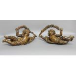 PAIR OF CARVED LIMEWOOD CHERUBS, possibly 18th century, holding floral garlands, length 43cm (2)