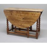 WALNUT GATELEG DINING TABLE, the oval top on bobbin turned legs and block stretchers, height 75.