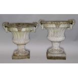 PAIR OF RECONSTITUTED STONE CAMPANA STYLE URNS, the flaring, fluted bodywith a pair of rope hoop