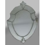 SHIELD SHAPED VENETIAN MIRROR, the bevelled plate inside a broad frame with stylised floral finial