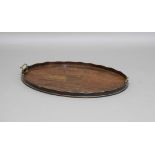 GEORGE III OVAL MAHOGANY AND BRASS INLAID TRAY, with a wavy gallery and pair of brass handles,