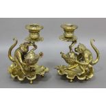 PAIR OF BRASS MONKEY CHAMBERSTICKS, cast as a monkey holding up a nut shell supporting a foliate