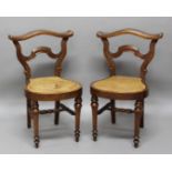 PAIR OF FRENCH WALNUT COCKFIGHTING CHAIRS, 19th century, the broad, wavy top rail and carved back